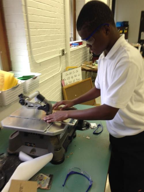 Stem Lab students using the scroll saw to execute the design of their jigsaw puzzle creation. 