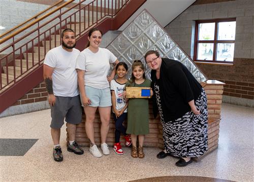 Photo of Isabella Gomez, family members, and Principal C.J. Huffman