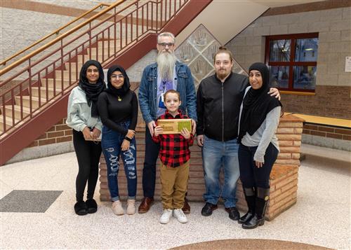 Jefferson's March Stairclimber, Liam Austin, posing with his plaque, family members and Assistant Principal Bayhurst.