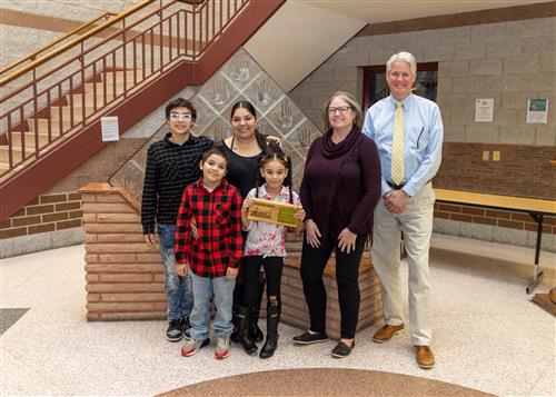 Diehl's March Stairclimber, Jaysmarie Vargas, posing with her plaque, family members, and school staff.