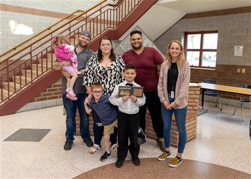 Mason Himelein, Grover Cleveland's May 2023 Stairclimber, poses with his plaque and family members.