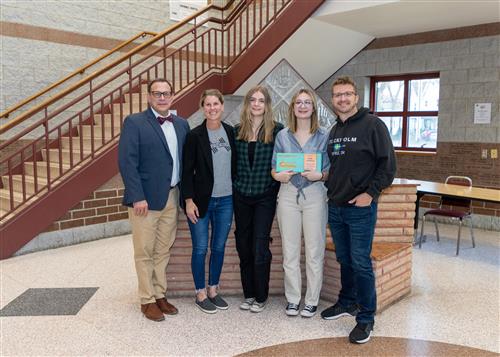 Sadie Lundberg, Collegiate Academy's March Stairclimber, poses with her plaque, family members and Dean Vieira.