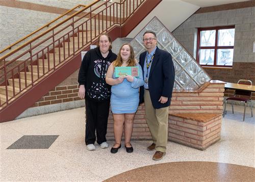 Jazmine Boyajian, PJD's March Stairclimber, poses with her plaque, a family member, and AP Sandberg.