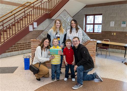 Andrew Botelho, Pfeiffer-Burleigh's March Stairclimber, poses with his plaque, family members, and Principal Jamie Brim.