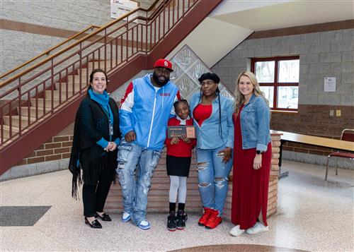 Ty'Jayia McKines, Edison Elementary's April Stairclimber, poses with her plaque, family members, and school staff.