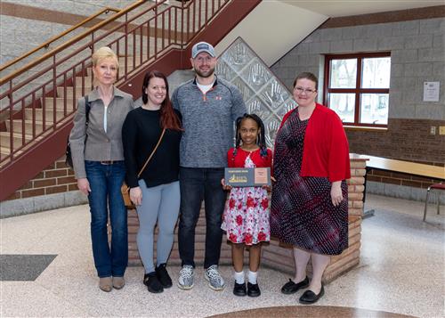 Shyann Carr, Lincoln Elementary's April Stairclimber, poses with her plaque, family members and Principal C.J. Huffman.