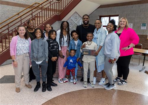 Durfey Wells, Perry Elementary's April Stairclimber, poses with his plaque, family members, and school staff.