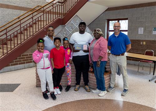 Ronald Gillespie, Erie High School's April Stairclimber, poses with his plaque, family members, and Principal Don Orlando.