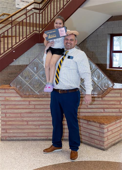 Lillyanna Lipinski, Jefferson Elementary's April Stairclimber, poses with her plaque atop Principal Jeff Boam's shoulders.