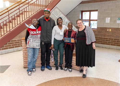 Azonte Nixson, Lincoln Elementary's May Stairclimber, poses with his plaque, family members, and Principal CJ Huffman.