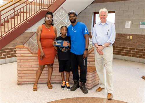 Dae'Veion Beard, Diehl Elementary's May Stairclimber, poses with his award, family members, and Principal Tim Sabol.