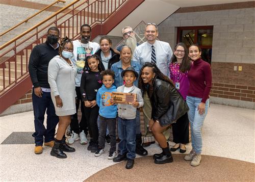 Denaro Russell, Jefferson's November 2022 Stairclimber, posing with many family members and Principal Jeff Boam.