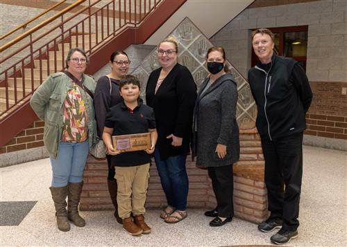 Charles Anaya, Perry's November 2022 Stairclimber, standing with family and Principal David Eubank.