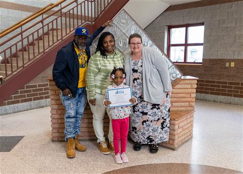 Photo of Jaurae Miller, family members, and Principal C.J. Huffman.