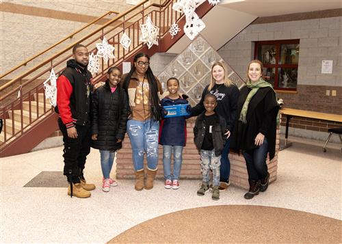 Ethan Vaughn, Edison's January Stairclimber, poses with his plaque, family members, and school staff.