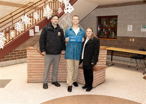 Darius Bahling, Erie High's January Stairclimber, poses with his plaque, a family member,  and AP Jeff Brzezinski.