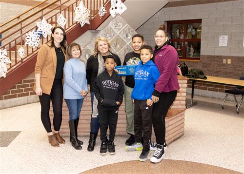 Messiah Mooney Hughes, Wilson's January Stairclimber, poses with his plaque, family members, and school staff.