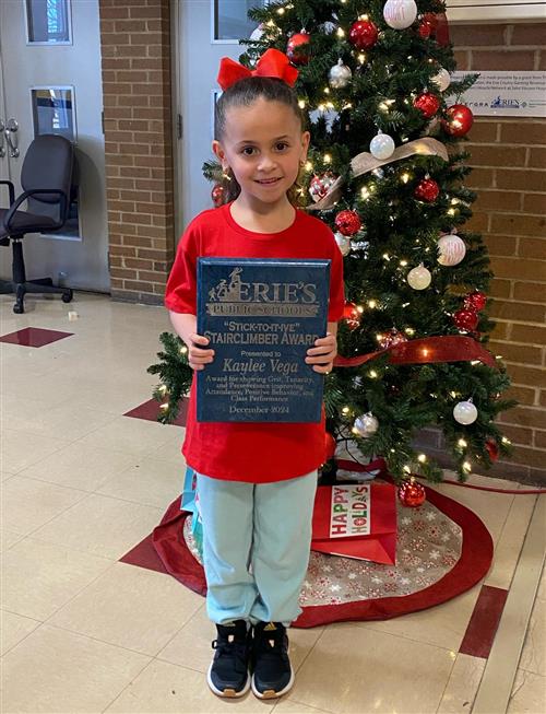 Kaylee Vega, Grover Cleveland's Stairclimber for December, poses with her award plaque.