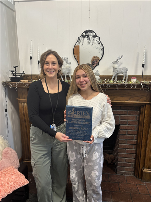 Jasmine Cruz, Collegiate Academy's Stairclimber for December, poses with a school staff member and her plaque.