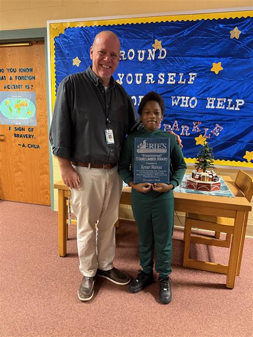 Kevar Manus, Harding's December Stairclimber, poses with his plaque and Assistant Principal Yonkers.