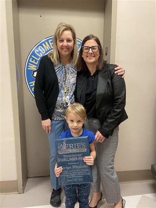 Mariyan Wieczorek,, Jefferson's Decemeber Stairclimber, poses with school staff and her award.