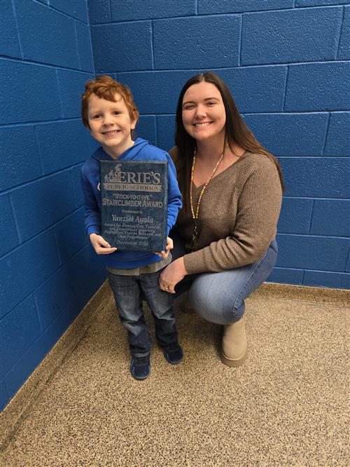 Yanziel Ayala, Pfeiffer-Burleigh's December Stairclimber, and a staff member pose with his award.