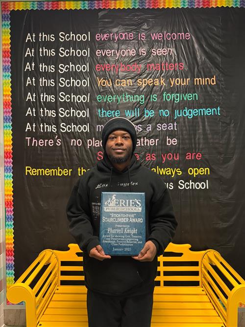 Pharrell Knight, January Stairclimber for the DiPaolo Student Success Center, poses with his plaque.