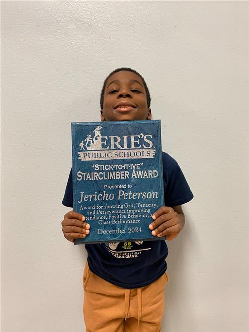 Jericho Peterson, DiPaolo Student Success Center's December Stairclimber, poses with his plaque.