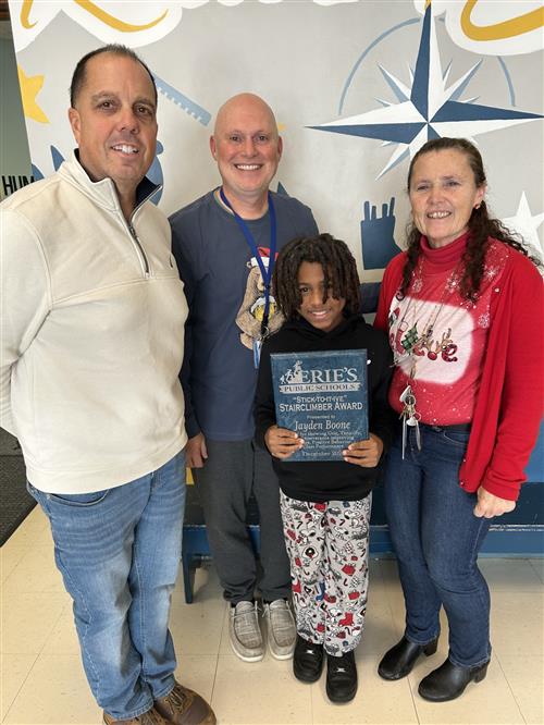 Jayden Boone, Perry's December Stairclimber, poses with his plaque and school staff.