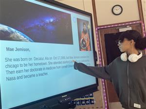 A student presents information she learned about Mae Jemison in front of the class.