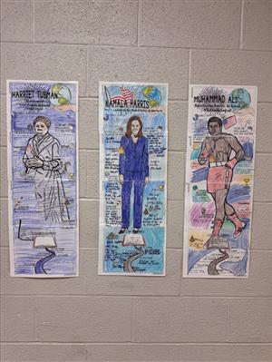 Photo shows posters, colored by students, highlighting Tubman, Harris and Muhammad Ali.