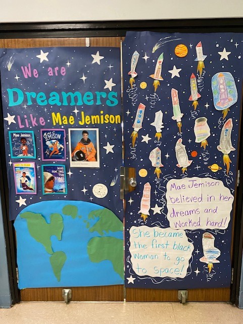 Photo of a door covered in a an outer-space theme and featuring information about and photos of Mae Jemison.