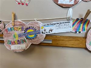 Closeup photo of a guitar, cut from paper and colored by a student.